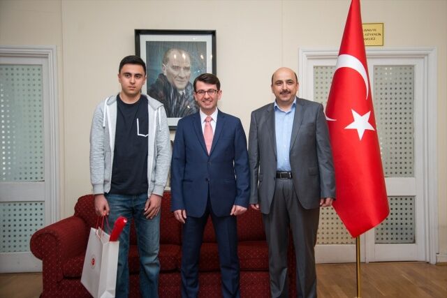 Manchester Selimiye Türk Okulundan İsmet Fatih Koçak&#039;a (solda), ödülünü Başkonsolos Emirhan Yorulmazlar verdi. Öğrencinin babası Osman Koçak (sağda).